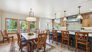 Une cuisine spacieuse avec des meubles en bois, un grand îlot central et des luminaires suspendus.