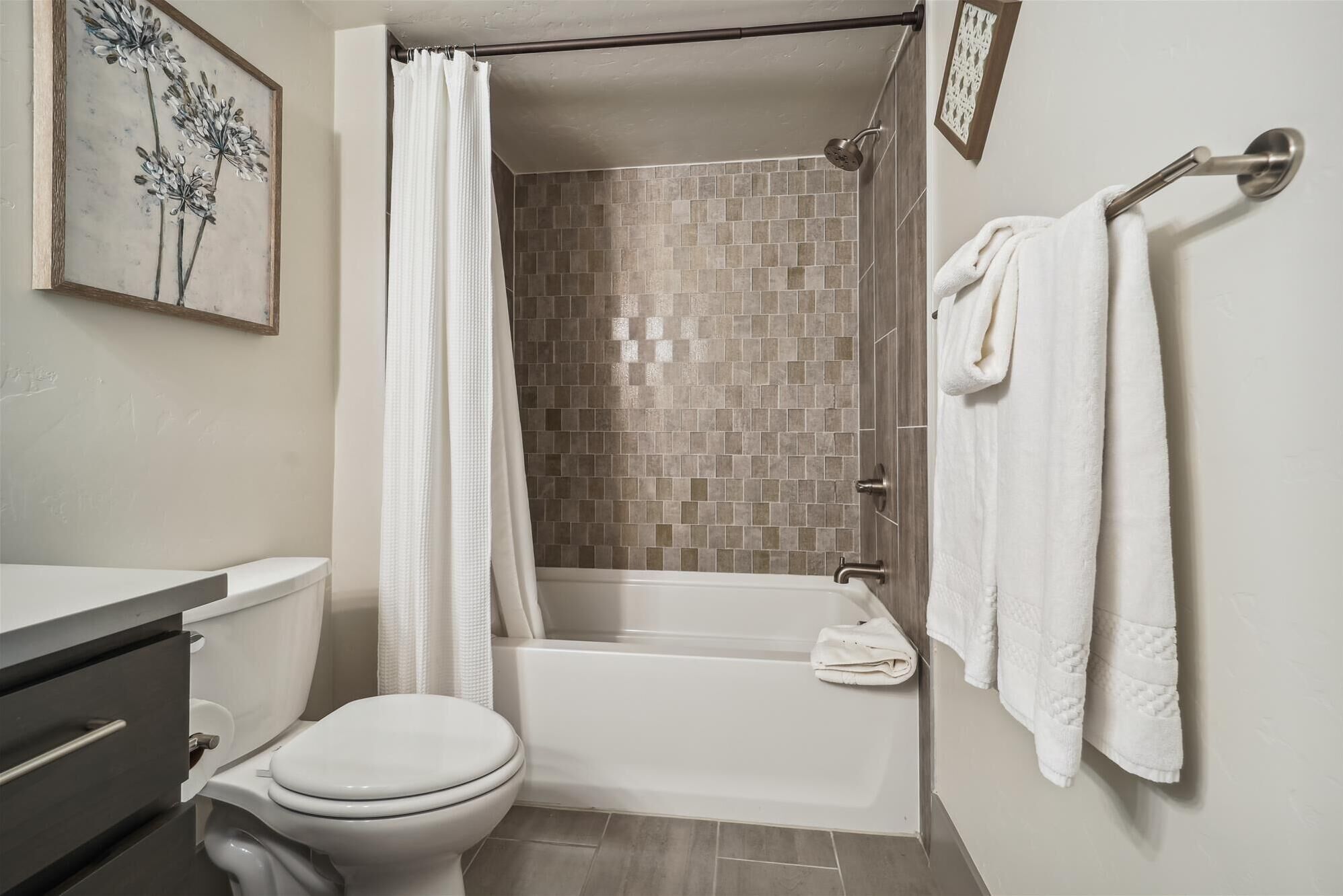 Un baño con inodoro, bañera y cortina de ducha.