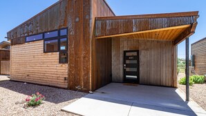 Un edificio moderno con fachada de madera y una puerta negra marcada con el número 451.