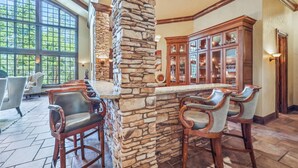 A bar area with stone pillars, wooden chairs, and a bar counter. - 8,000+ Sq Ft Breck Ski Home, Hot Tub, Theater, Pool Table, Sleeps 14 (Breckenridge)