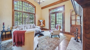 A spacious living room with a large sofa, a smaller armchair, and a painting on the wall. - 8,000+ Sq Ft Breck Ski Home, Hot Tub, Theater, Pool Table, Sleeps 14 (Breckenridge)