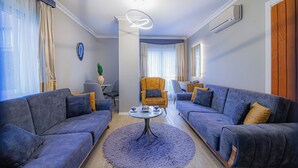 Un salon moderne avec deux canapés, une table basse et un fauteuil.