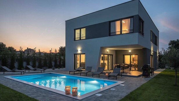 A modern two-story house with a swimming pool, outdoor seating, and a well-lit patio area. - Villa Tika in Jadreski (Jadreski)