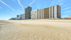 A beachfront hotel with multiple high-rise buildings, sandy beach in the foreground, and clear skies. - Marigot Beach 303 2 Bedroom Condo by RedAwning (Ocean City)