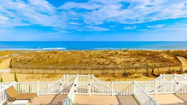 A beach view from a balcony with a wooden deck and white railings. - Pilot House 5 4 Bedroom Townhouse by RedAwning (Ocean City)