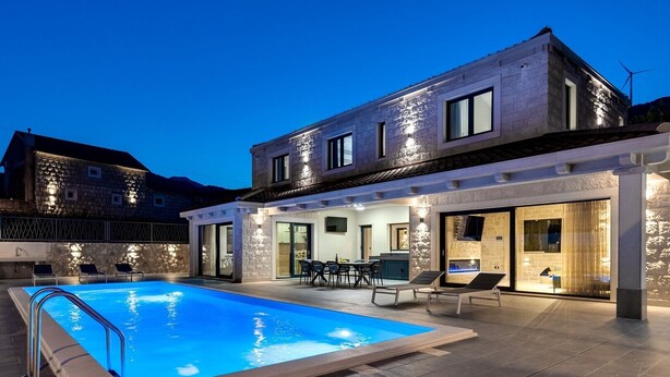 A modern house with a swimming pool, outdoor seating, and a stone facade. - Villa Neven with heated private pool,wine cellar (Seoca)