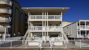 A multi-story building with balconies, a wooden deck, and a sign indicating private property. - Alameda 5 2 Bedroom Condo by RedAwning (Ocean City)