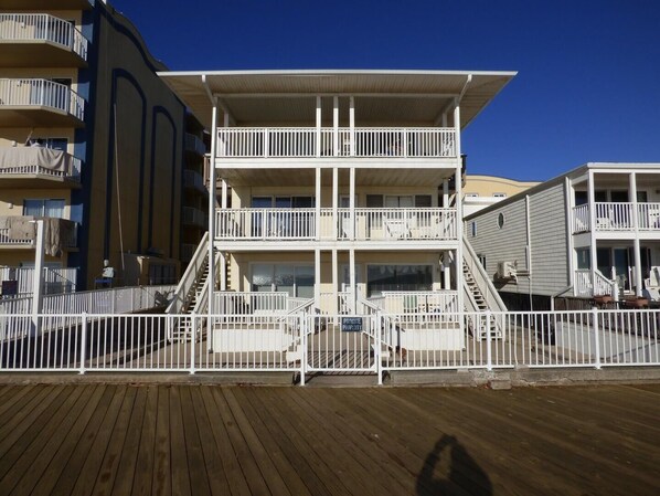 A multi-story building with balconies, a wooden deck, and a sign indicating private property. - Alameda 5 2 Bedroom Condo by RedAwning (Ocean City)
