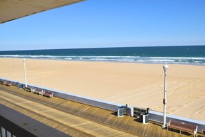 A beach view from a balcony with a wooden deck, two street lamps, and a bench. - Alameda 5 2 Bedroom Condo by RedAwning (Ocean City)