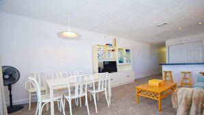 A compact living space with a dining area, a television, and a kitchenette.