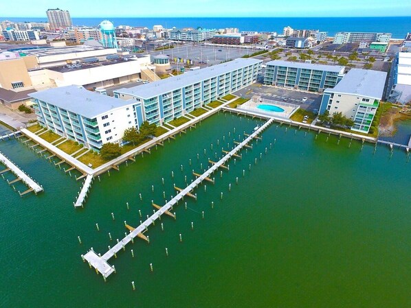 A modern hotel with a marina, featuring multiple buildings connected by walkways over water. - Thunder Island 16a 2 Bedroom Condo by RedAwning (Ocean City)