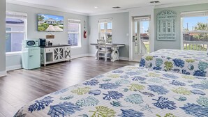 A bedroom with two beds, a desk, and a kitchenette. - Coast Oaks Cottage 5 1 Bedroom Cottage by RedAwning (Rockport)