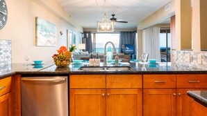 A modern kitchen with wooden cabinets, a stainless steel dishwasher, and a granite countertop. - Sands Of Kahana 315 2bd/2ba Oceanfront 2 Bedroom Condo by RedAwning (Lahaina)