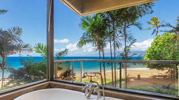 A bathroom with a bathtub and a view of the beach and ocean through a large window. - Sands Of Kahana 315 2bd/2ba Oceanfront 2 Bedroom Condo by RedAwning (Lahaina)