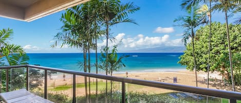 A balcony with a view of a beach and ocean.