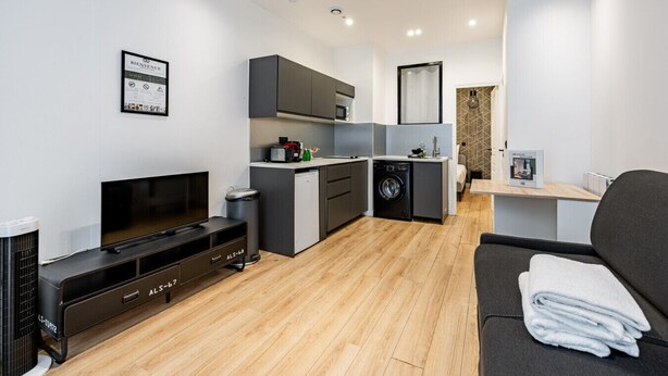Eine moderne Wohnung mit Küchenzeile, Essbereich und Wohnzimmer.