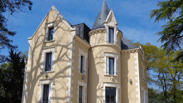 A large, historic building with multiple windows and a turret. - Le Château des Plans (Parthenay)