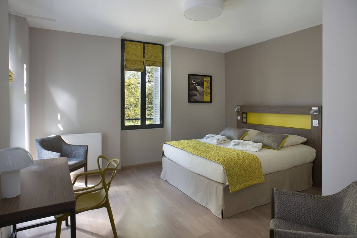 Um quarto moderno com uma cama, uma escrivaninha e uma cadeira.