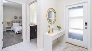 A hotel hallway with a white console table, a mirror, and a door with frosted glass panels. - Last Minute Disney Getaway! Townhouse with Private Pool. Book Now! #38174 (Orlando)