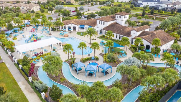 Eine Luftaufnahme eines Resorts mit Schwimmbad, Palmen und Liegebereichen.