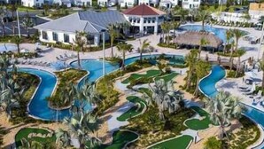 Ein Resort mit mehreren Schwimmbecken, Palmen und einem großen Gebäude mit rotem Dach.