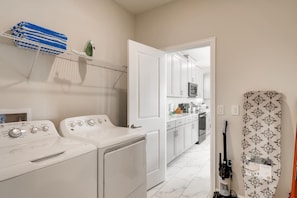 A laundry area with a washing machine, dryer, and stacked towels.