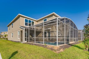 Une maison à deux étages dotée d’un grand patio entièrement vitré.