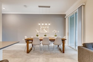 A dining area with a wooden table, six chairs, and a chandelier.