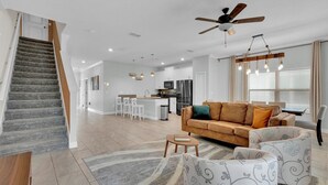A spacious living area with a staircase, a kitchen, and a dining area. - Last Minute Disney Getaway! Private Pool & Themed Bedrooms. Book Now! #59141 (Orlando)