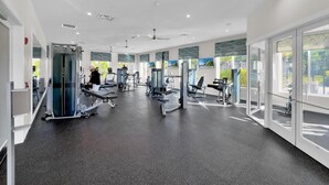 A modern gym with various exercise machines, large windows, and a clean, spacious layout. - Last Minute Disney Getaway! Private Pool & Themed Bedrooms. Book Now! #59141 (Orlando)