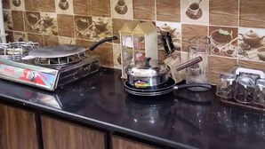 Una cocina con estufa a gas, una olla a presión y diversos utensilios de cocina.