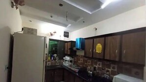 Una cocina compacta con armarios de madera oscura, un horno empotrado y un microondas.