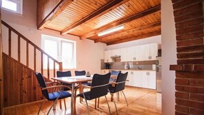 Una cocina amplia con armarios blancos y techo de madera.