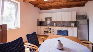 Cocina compacta con muebles de madera, microondas y refrigerador.