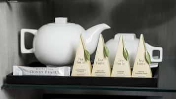 A shelf with tea bags and a teapot.
