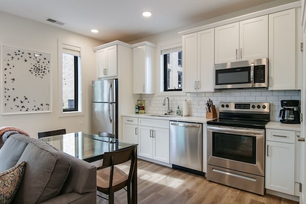 Enjoy meals and relaxation in this kitchen with a dining table and sofa.