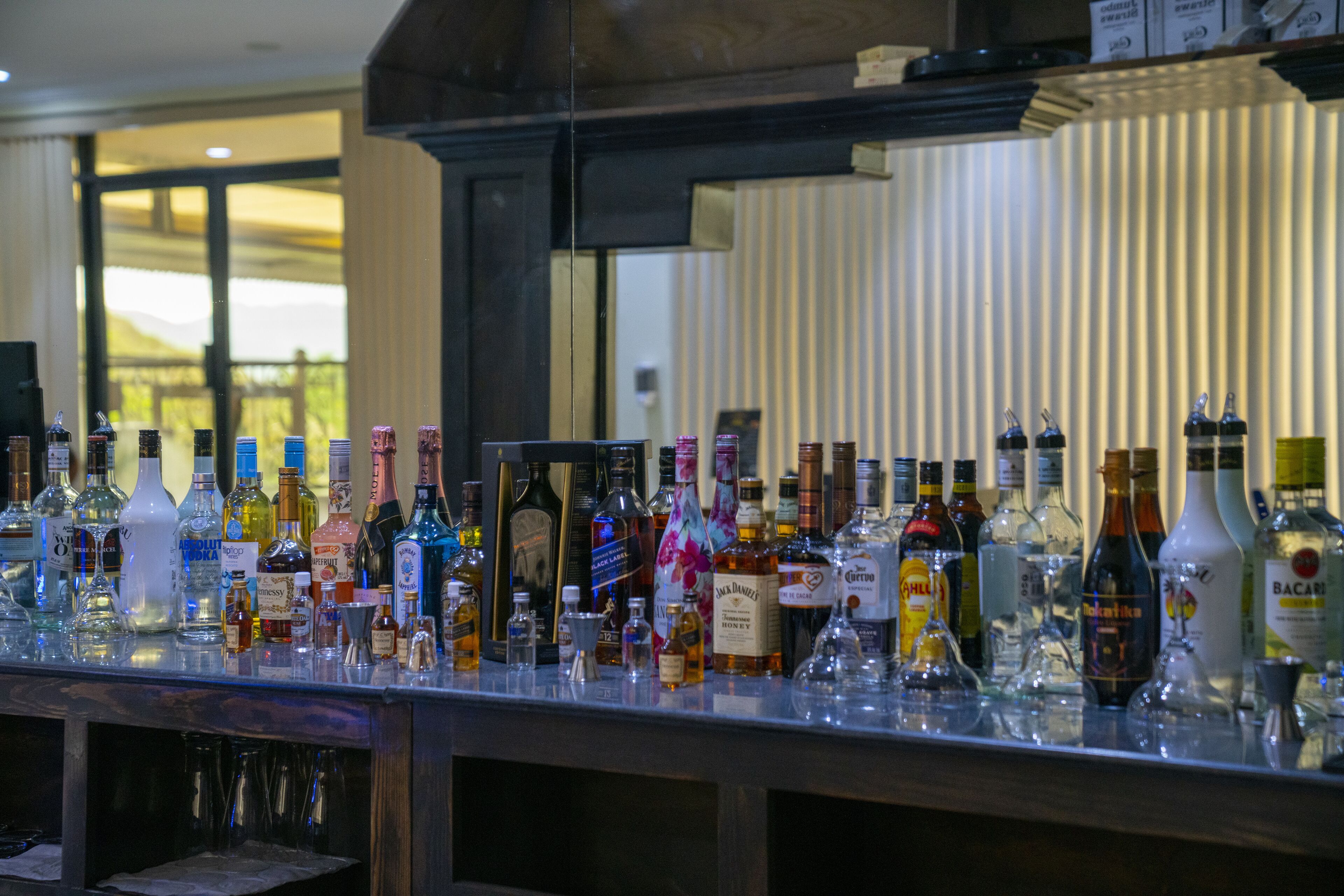 Een bar met verschillende drankflessen en glazen.