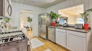 A modern kitchen with stainless steel appliances, wooden flooring, and white cabinetry. - Dock & Boat Slip! Waterfront Lake Ozark Home (Lake Ozark)