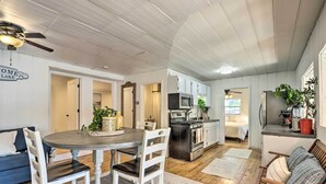 A compact kitchen with a dining area, wooden floors, and white cabinetry. - Dock & Boat Slip! Waterfront Lake Ozark Home (Lake Ozark)