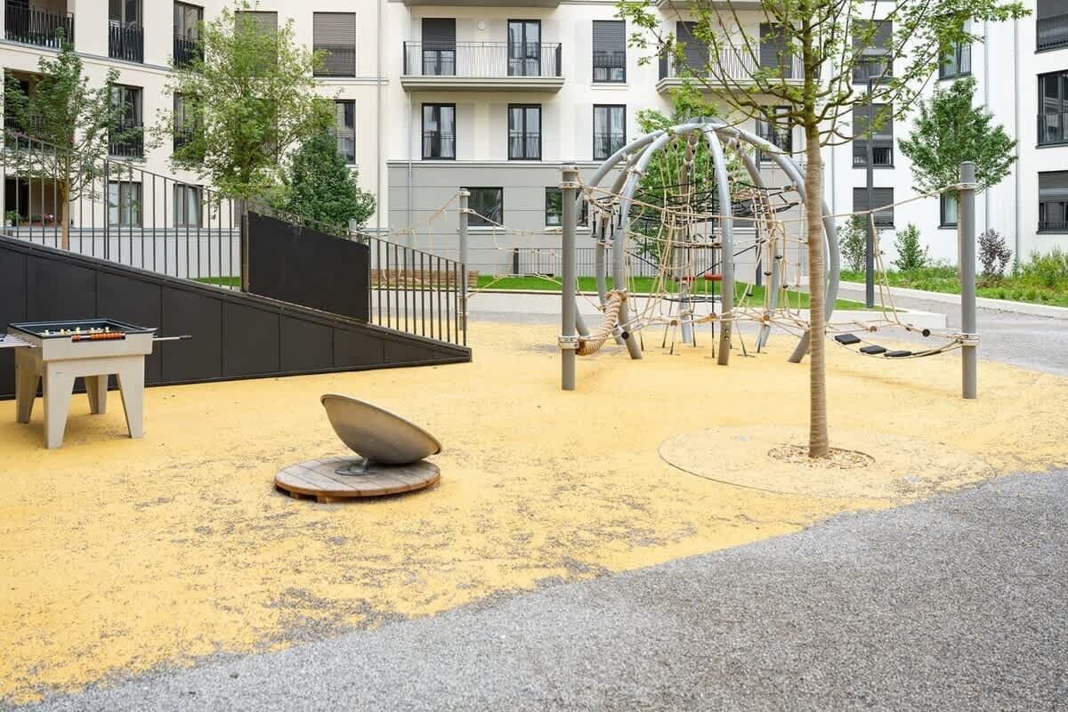 Ein Spielplatz mit Klettergeräten und einer Sitzgelegenheit.