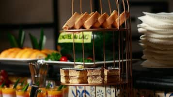 Un buffet proposant une variété de desserts et d’en-cas, notamment des gâteaux, des pâtisseries et des fruits.