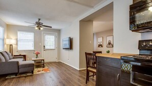 A living room with a sofa, a coffee table, a TV, and a ceiling fan. - prof cleaned*Peaceful & Close 2 Dwntwn (Dallas)