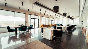 A spacious restaurant with high ceilings, large windows, and a modern interior design. - Mount Alverno Luxury Resorts (Caledon)