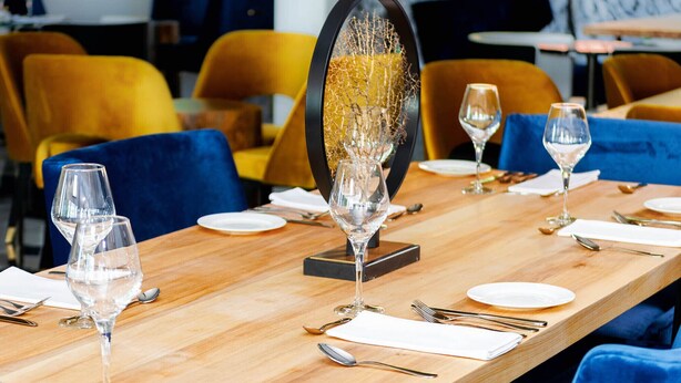 A dining table set with wine glasses, plates, and cutlery, with a decorative centerpiece. - Mount Alverno Luxury Resorts (Caledon)