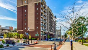 A multi-story hotel with a brick facade, balconies, and a parking lot in front.