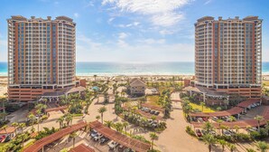 A beachfront hotel with two tall buildings, a beach, and a pool area. - New Listing P2-1106 2B Gulf View at Portofino! (Pensacola Beach)