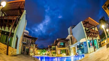 Una piscina al aire libre, sombrillas, sillones reclinables de piscina