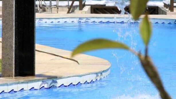A pool with a water feature, lounge chairs, and a view of the ocean. - Hotel Arrecife dos Corais (Cabo de Santo Agostinho)