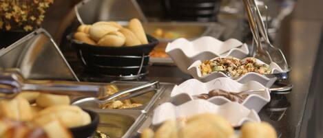 A buffet with various food items in bowls and containers.