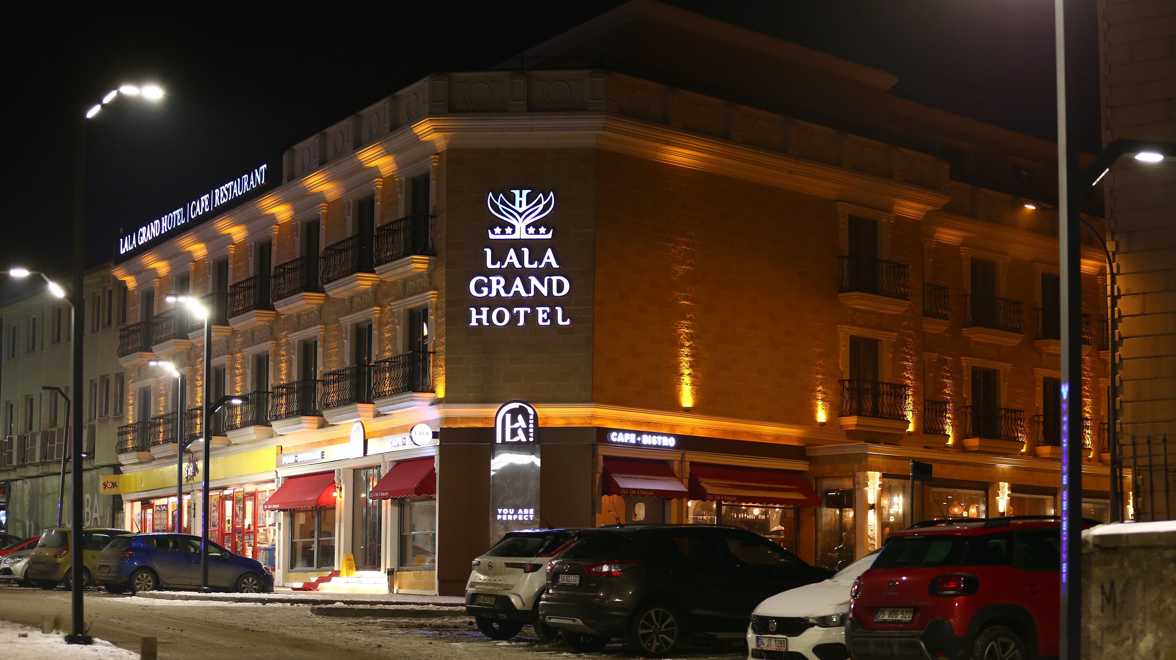 Le Grand Hôtel Lala, reconnaissable à son enseigne imposante, ses nombreux balcons et son rez-de-chaussée où se trouvent un café et un restaurant.
